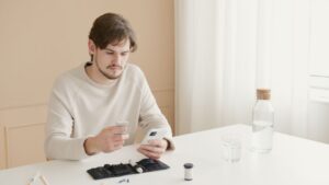 Un jeune homme vérifie son taux de glucose dans le sang à l'aide d'un glucomètre chez lui.
