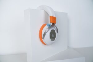 Casque supra-auriculaire élégant avec une touche orange, parfait pour les passionnés de technologie.