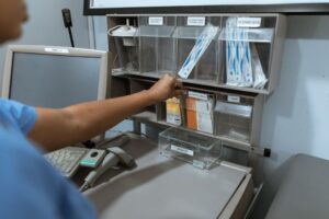 Un professionnel de la santé organise des fournitures médicales dans une salle de clinique, se concentrant sur un stockage efficace.